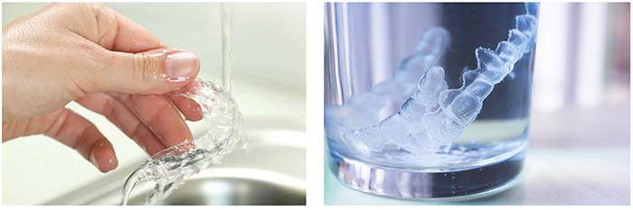 Primer plano de la limpieza de la ortodoncia removible con agua y jabón, y de un vaso con los alineadores y pastillas efervescentes